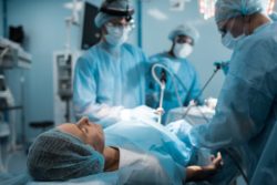 Surgeons removing transvaginal mesh device