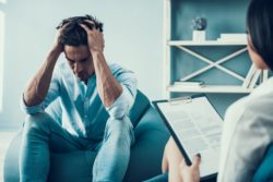 Frustrated man in therapy regarding information on long term disability insurance for mental health 