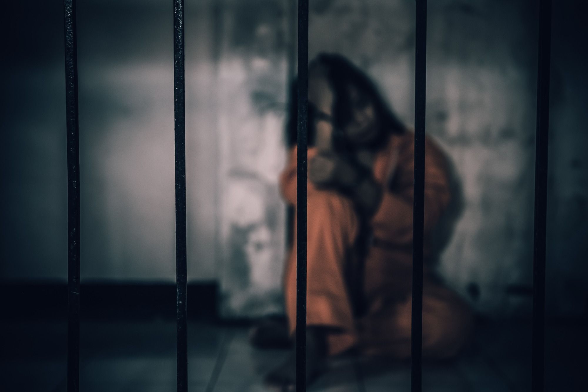 woman sitting behind bars regarding the Nunavik detainees class action lawsuit