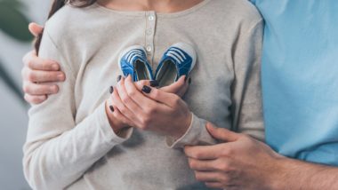 Woman holding baby shoes embraced by man regarding the Adoption By Choice lawsuit filed after the Calgary adoptions agency closed