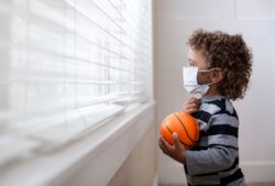 Little boy looking outside with mask on regarding the Vaccine Choice Canada lawsuit filed