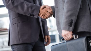 Insurance brokers handshake over secret kickback deal