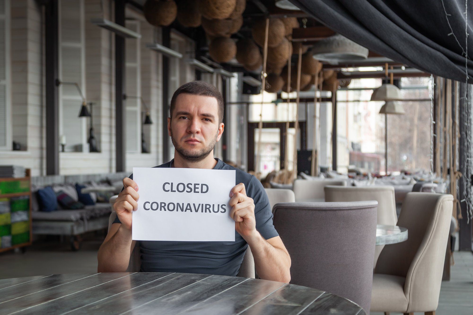 Business owner holding closed sign regarding information on business interruption insurance coverage 