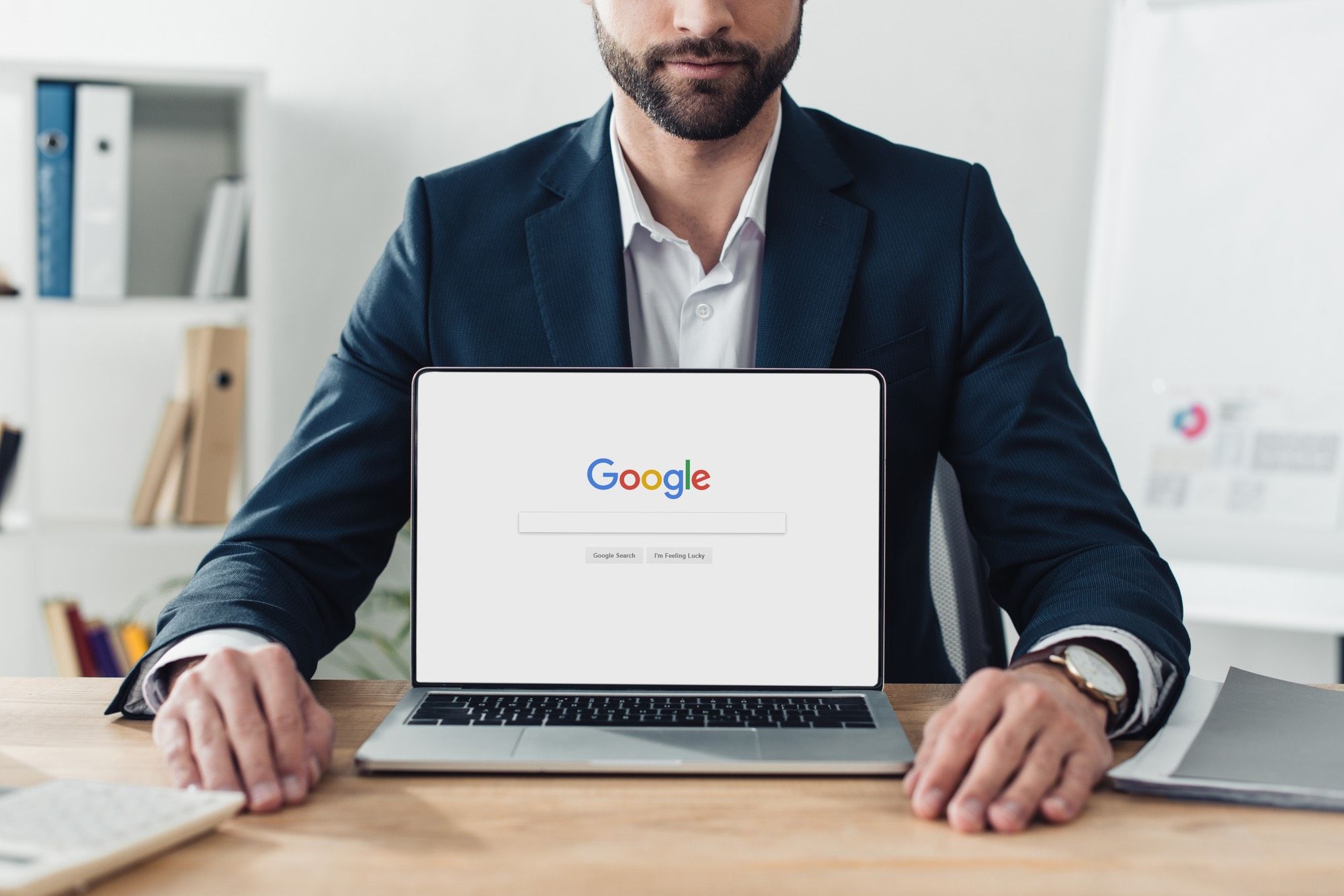 man sitting behind laptop on google page amid class action alleging privacy breaches