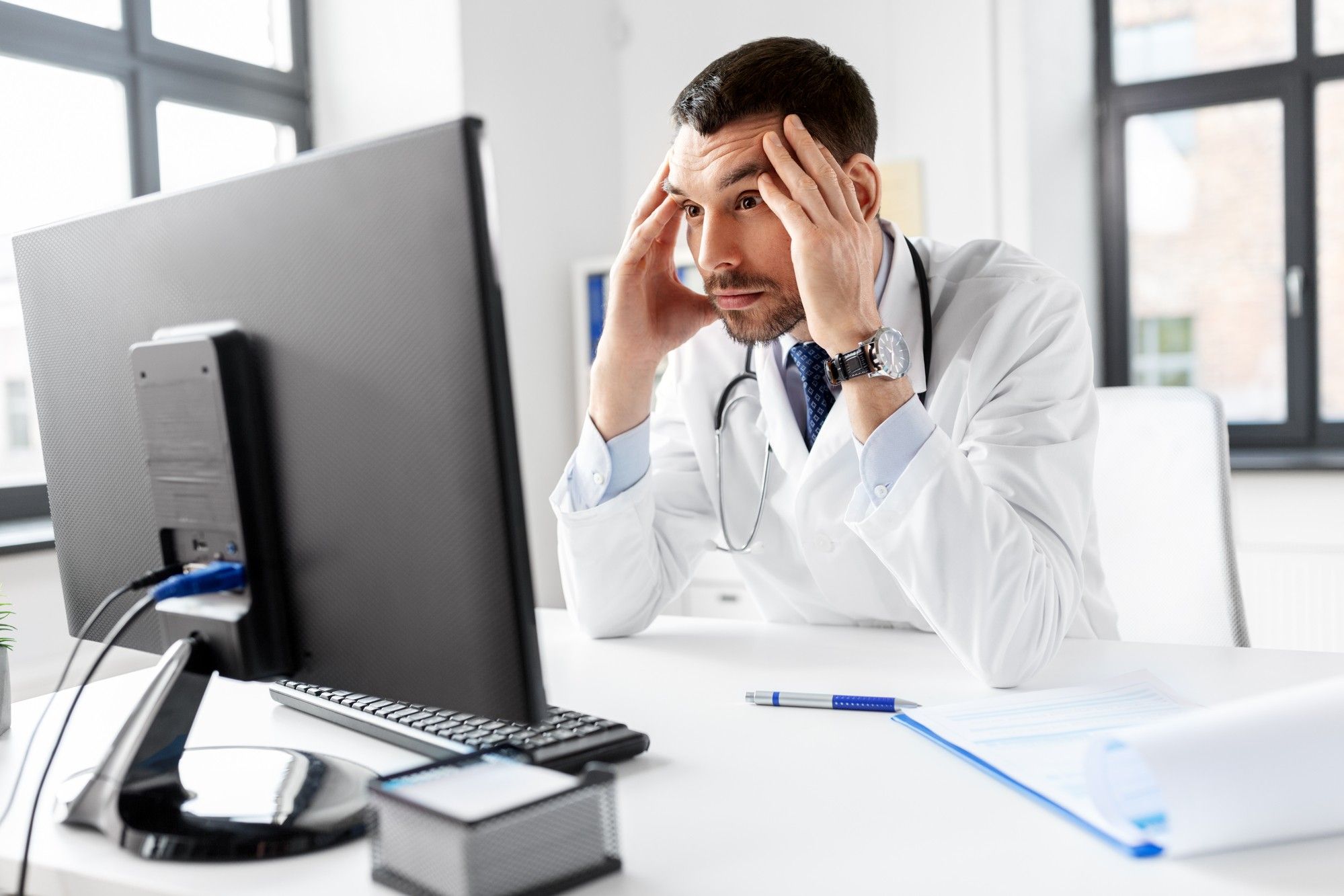 Stressed doctor realizing there's a data breach regarding the CarePartners class action lawsuit 