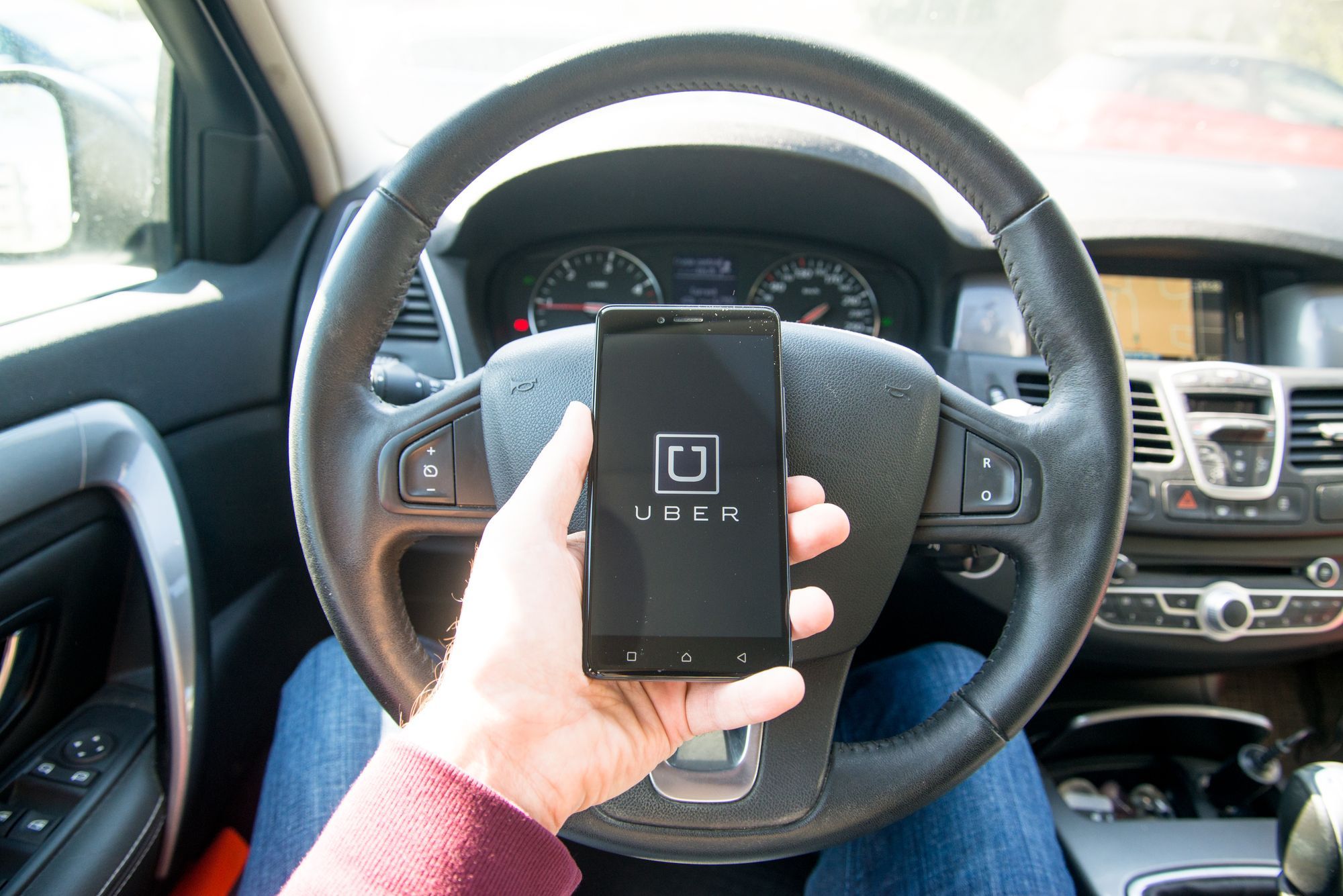Uber app on a drivers smartphone regarding the new contract Uber has drivers signing
