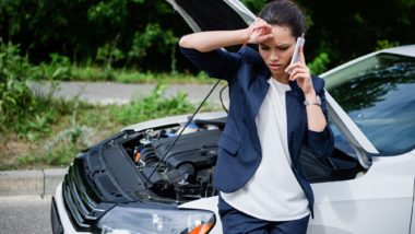 woman on phone with broken down car due to defective timing chain