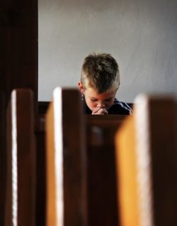 boy praying in church