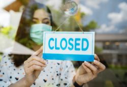 Business owner putting up closed sign regarding information on what to do if your business interruption claim is denied