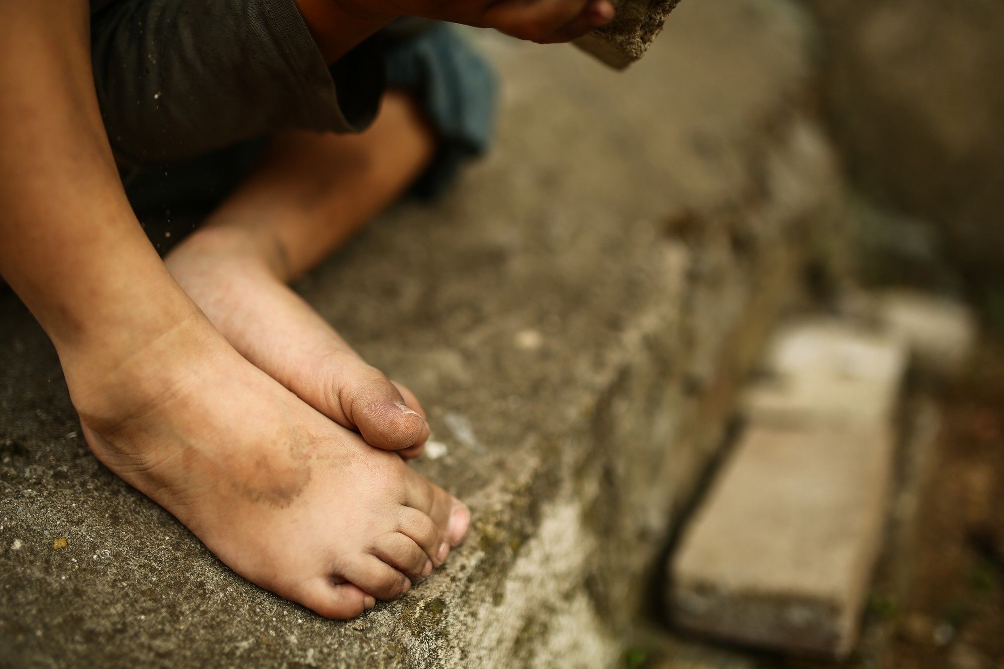 Homeless child's feet regarding the defrauded Indigenous foster children class action settlement