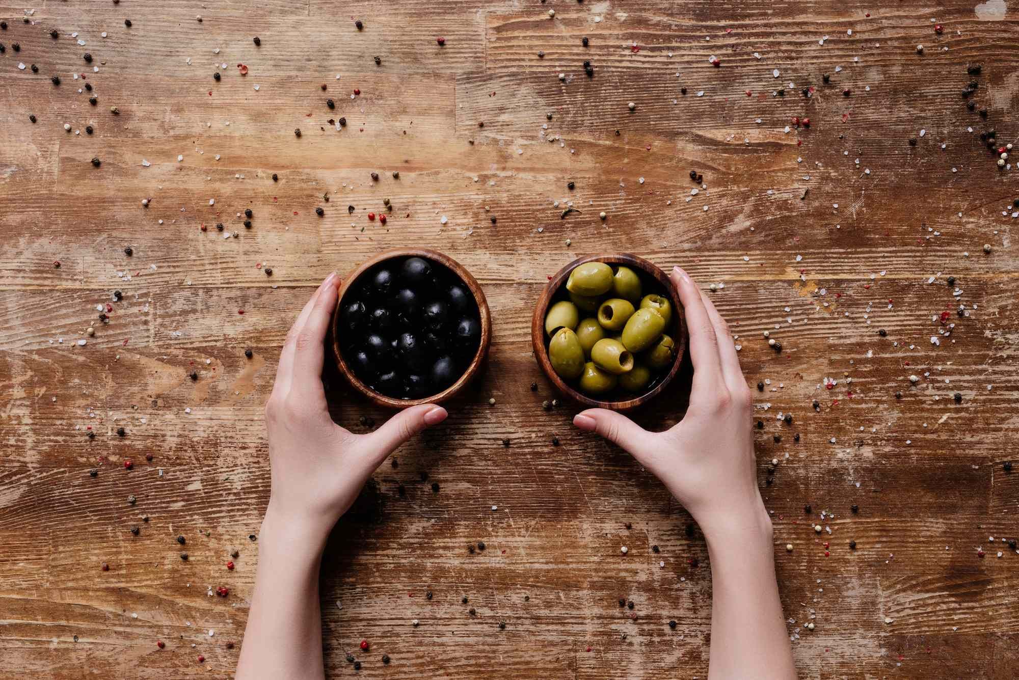 Person holding two types of olives regarding the fake black olives class action lawsuit 