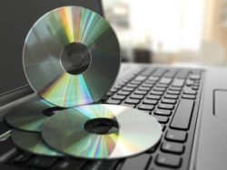CDs piled on laptop keyboard - optical disc drive