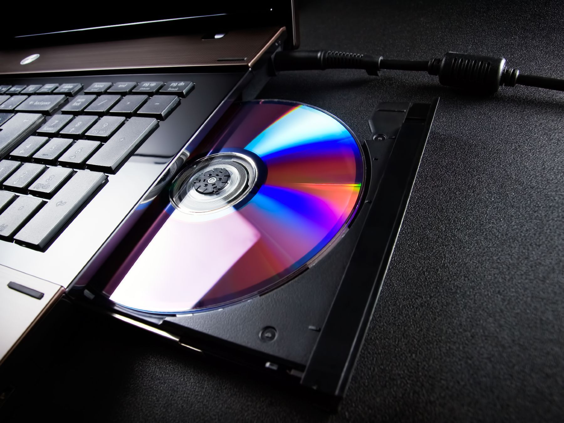 A CD in an optical disc drive on a laptop