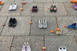 Empty shoes and painted rocks display remembering and honouring indigenous peoples residential school victims.