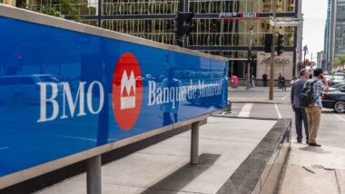People stand on a corner near a BMO Bank of Montreal sign - cibc
