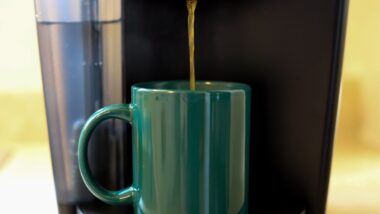 Coffee Dripping from a Brewer into a Green Mug