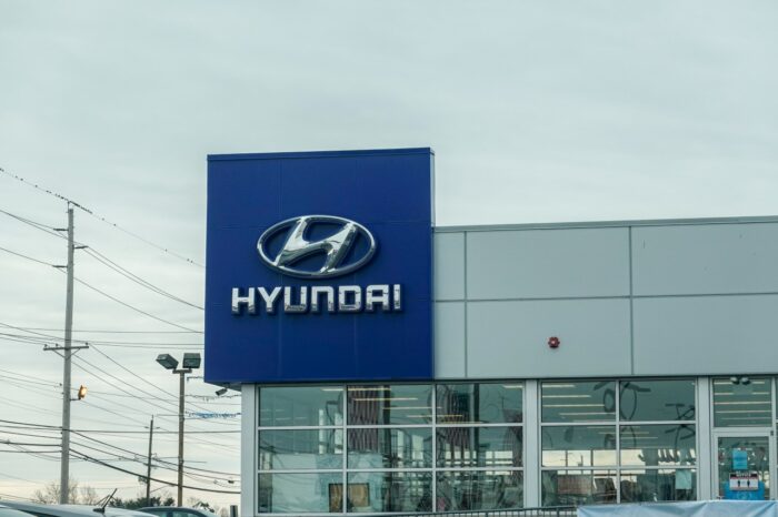Hyundai car dealership sign with silver logo on a blue background.