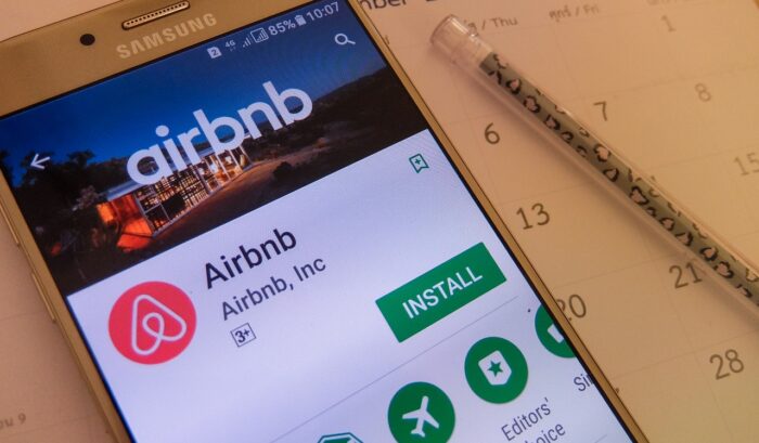airbnb application on smartphone screen - airbnb class action - airbnb service fees