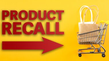 red text PRODUCT RECALL and arrow symbol against yellow background with shopping cart filled with shopping bags