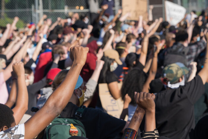 Protestors raise their hands in solidarity.