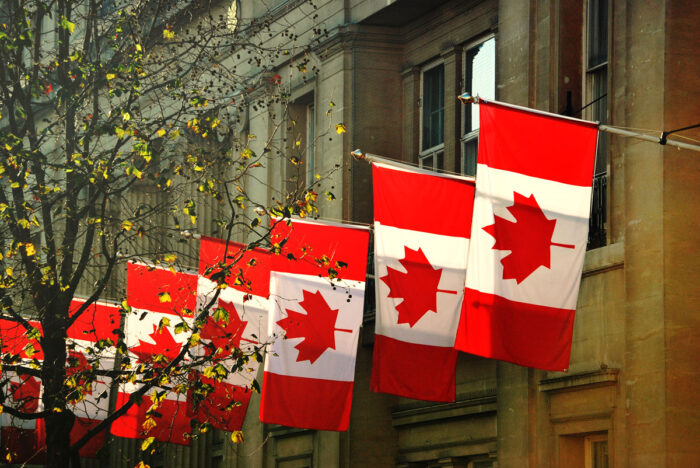 Close up of a row of Canadian flags outside Canada House in Trafalgar Square, London.