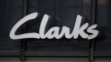 Close up of Clarks signage against a black wall.