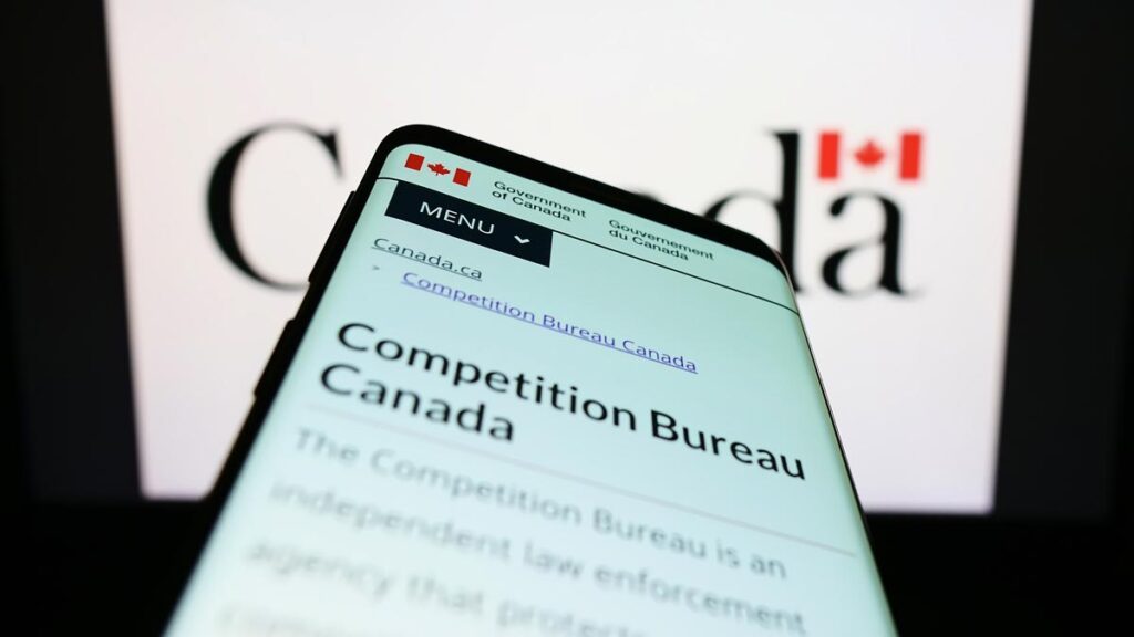 Mobile phone with web page of Canadian regulator Competition Bureau on screen in front of logo.