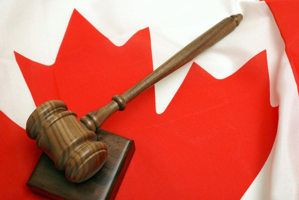 A wooden gavel on top of a Canada flag.