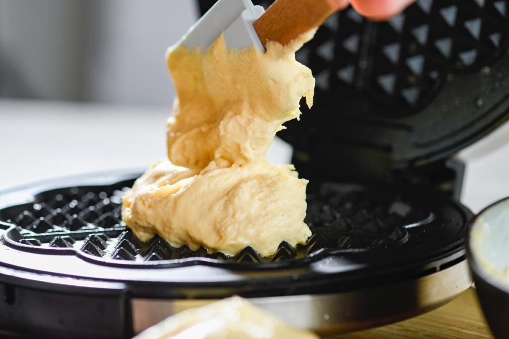 Close up of batter being poured into a waffle maker, representing the Empower Brands waffle maker recall.