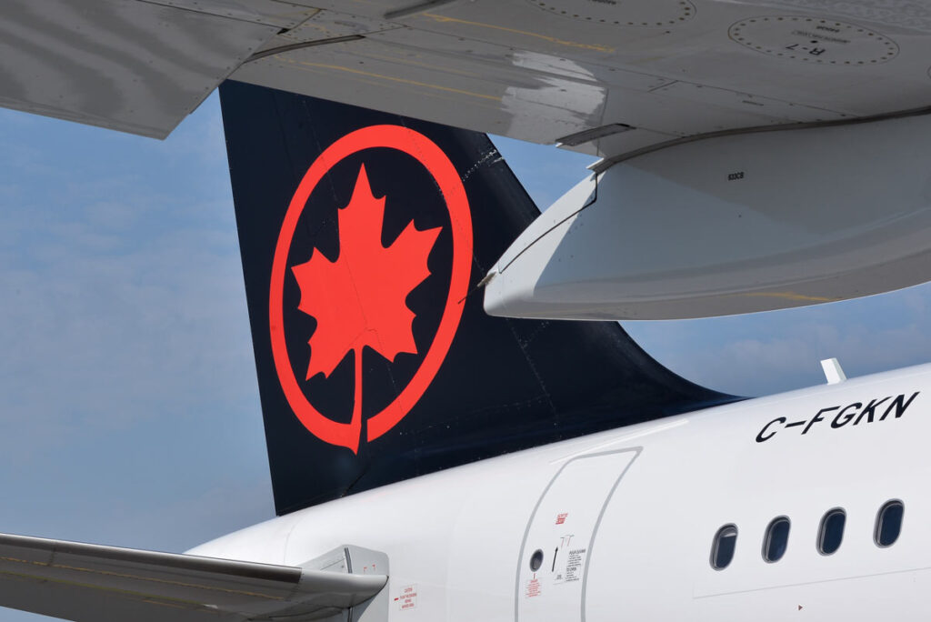 Air Canada airlines logo on tail of a plane, representing Air Canada flight delays.