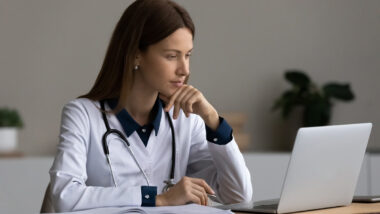 A medical professional using a laptop, representing the Health Employers Association of British Columbia data breach.