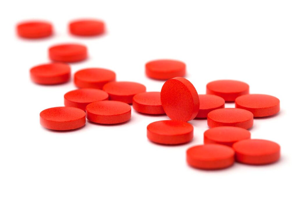 Close up of red tablets against a white backdrop, representing the B.C. cold medicine class action.
