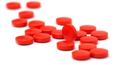 Close up of red tablets against a white backdrop, representing the B.C. cold medicine class action.