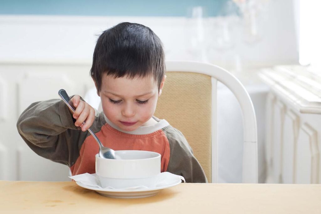 Young boy eating from a bowl, representing the Little Gourmet Organic Mealtime Bowls recall.