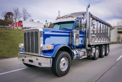 A blue heavy-duty work truck on the road, representing the Navistar MaxxForce engine class action settlement.